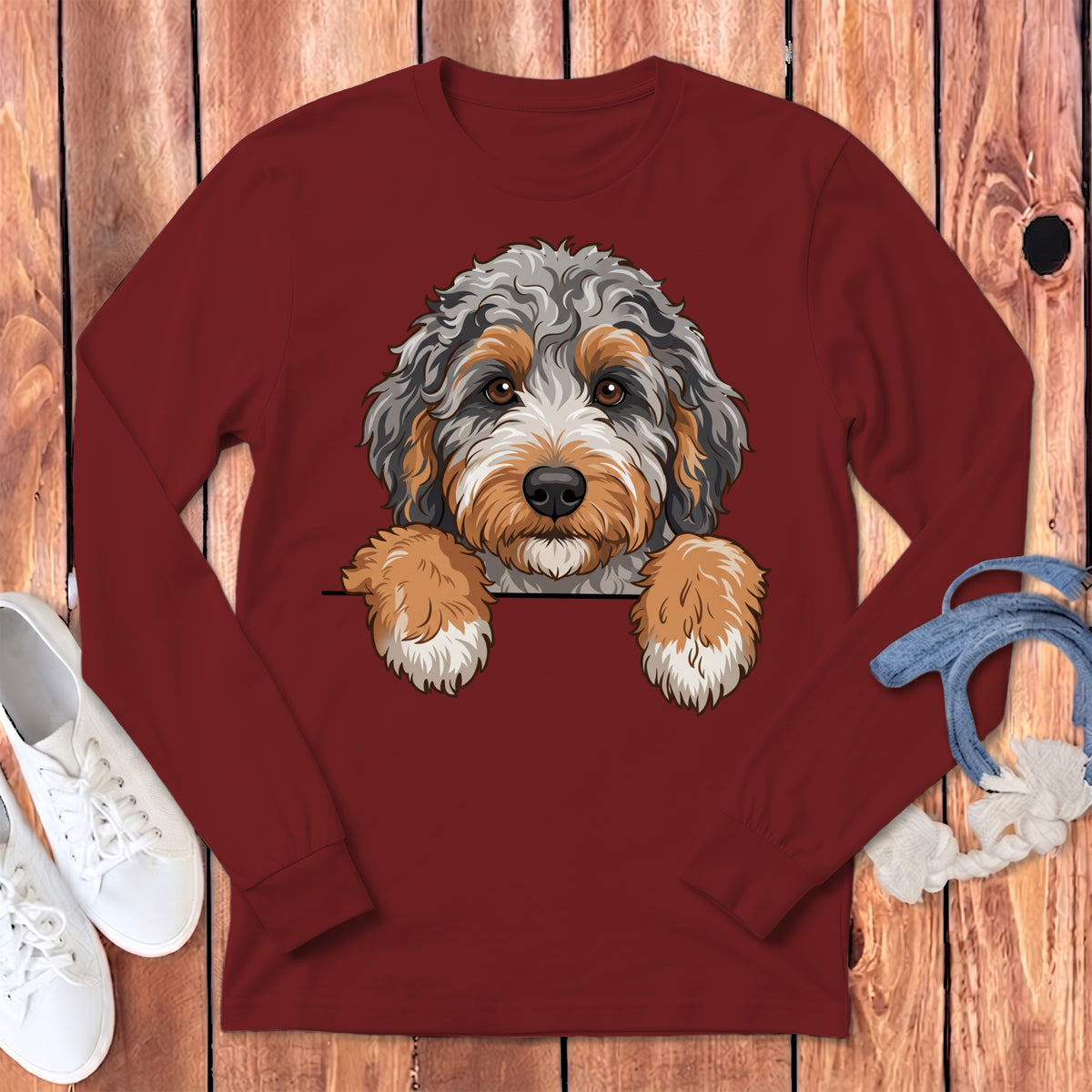 Long-sleeved maroon t-shirt with a doodle of a tricolor dog peeking over the top.