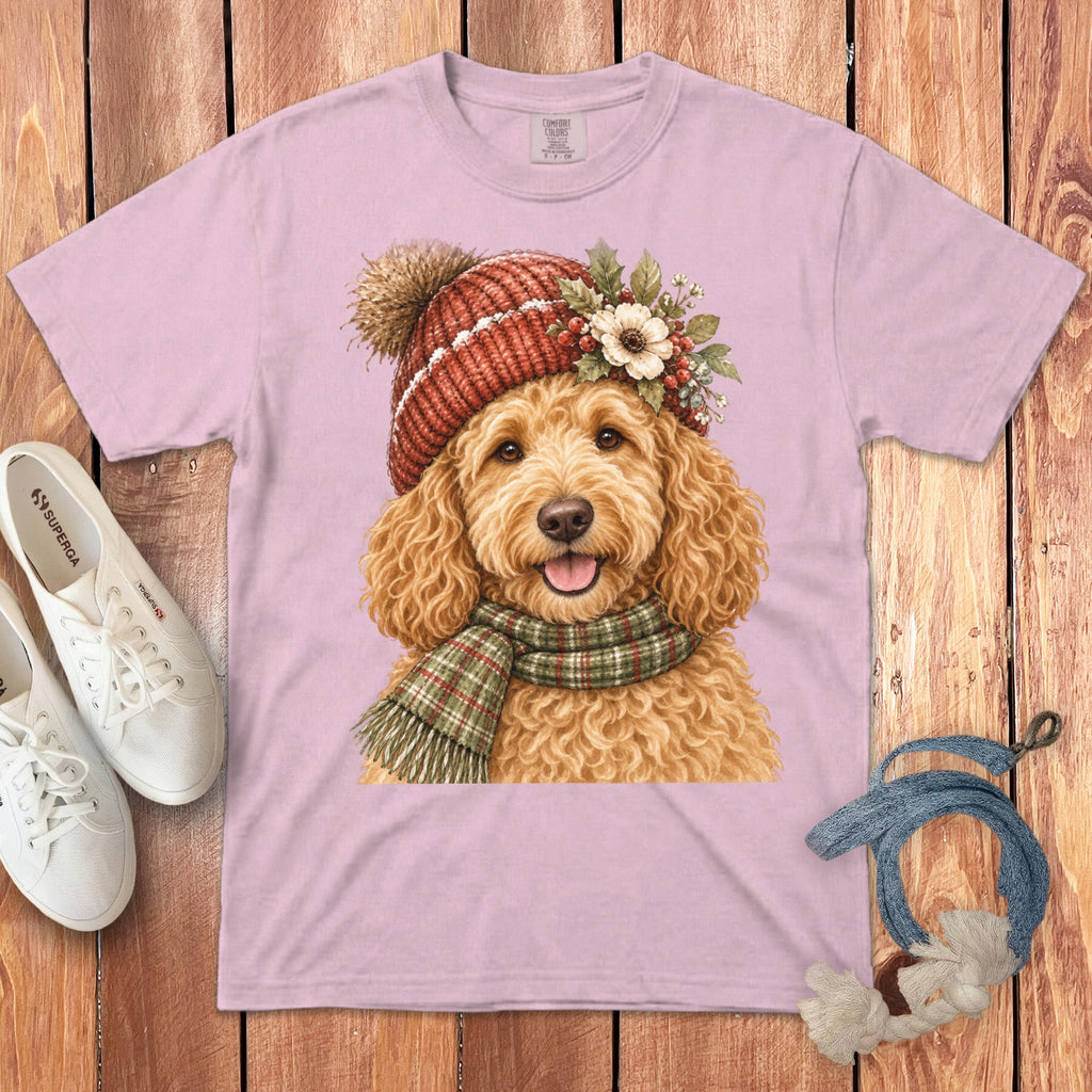 Pink t-shirt with a watercolor illustration of a goldendoodle wearing a beanie and scarf.