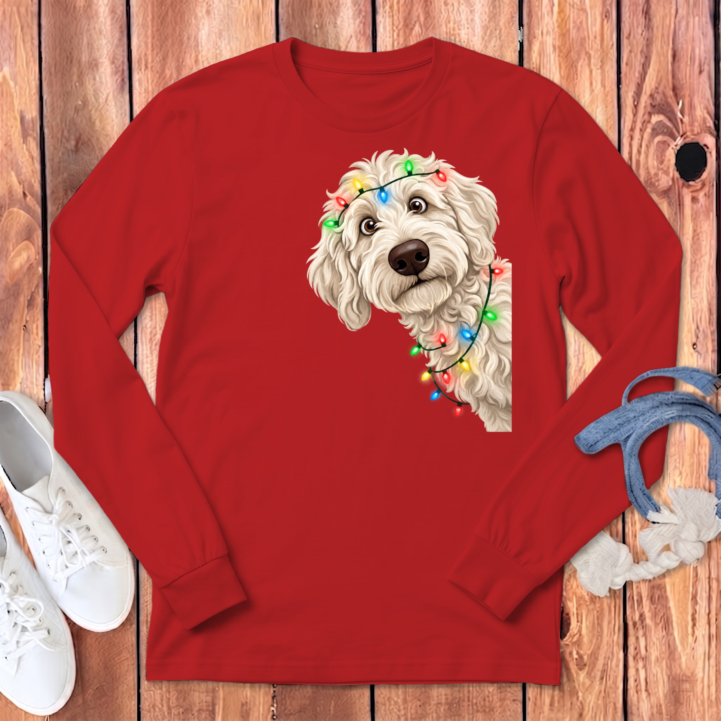 Red long-sleeve shirt with a white doodle dog wearing colorful Christmas lights.