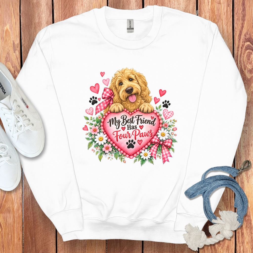 White crewneck sweatshirt featuring a graphic of a golden doodle resting its paws on a heart with the text My Best Friend Has Four Paws surrounded by flowers, hearts, and paw prints.