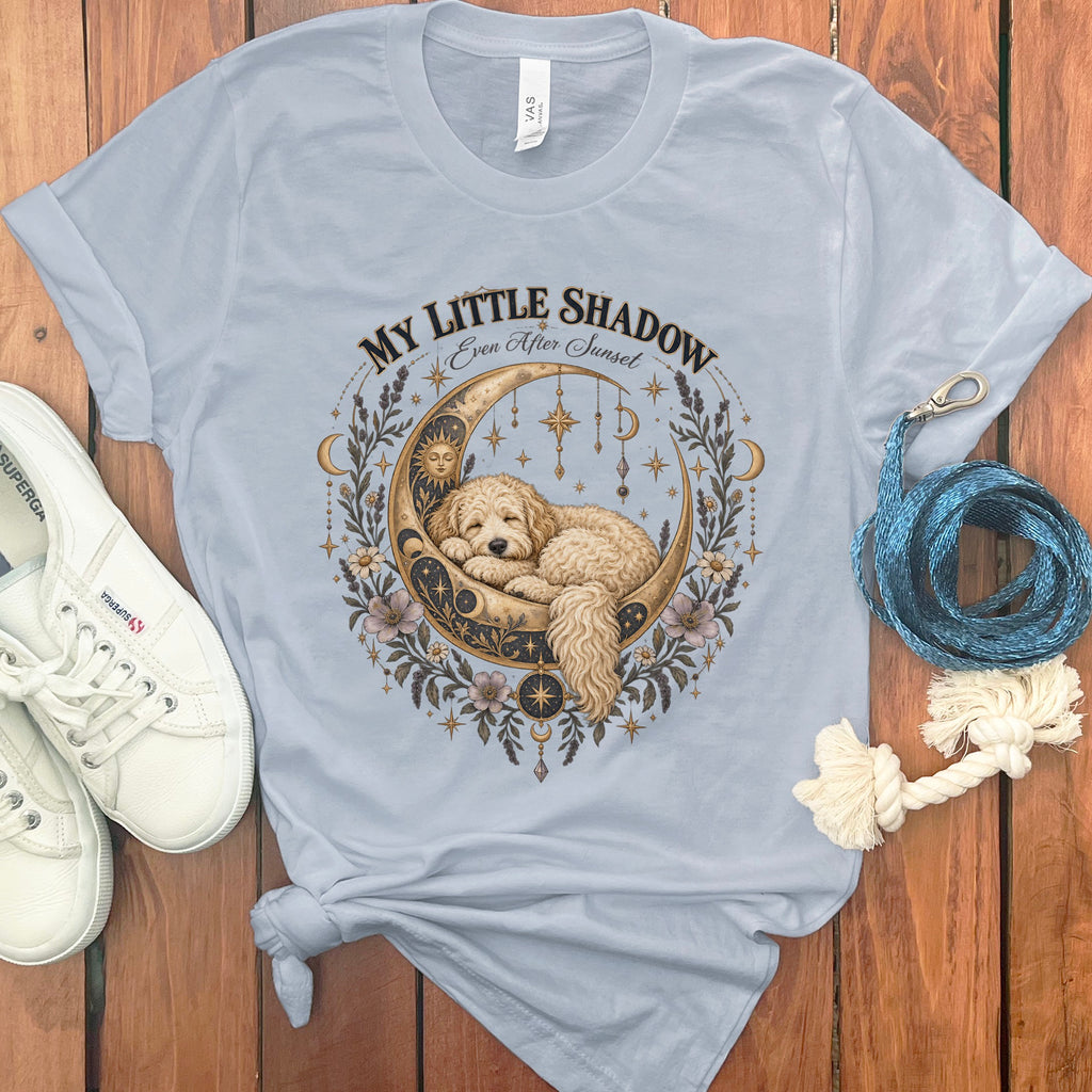 Light blue t-shirt with a dog sleeping on a crescent moon with celestial elements.