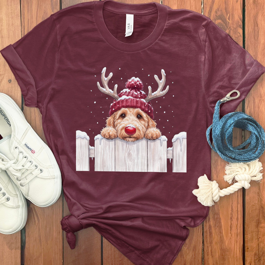 Burgundy t-shirt with cartoon dog wearing a Santa hat and antlers over a fence.