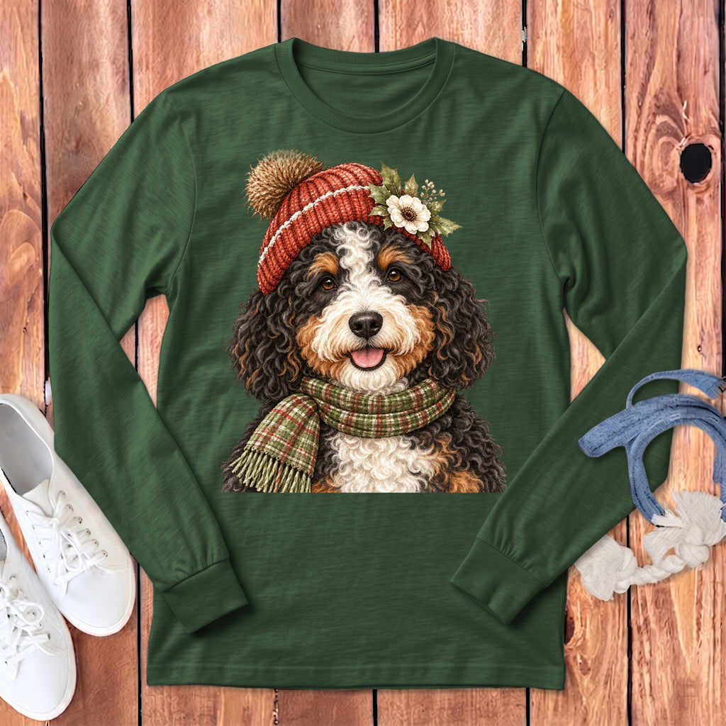 Bernese mountain dog wearing a knit hat and plaid scarf on a green long-sleeve shirt.