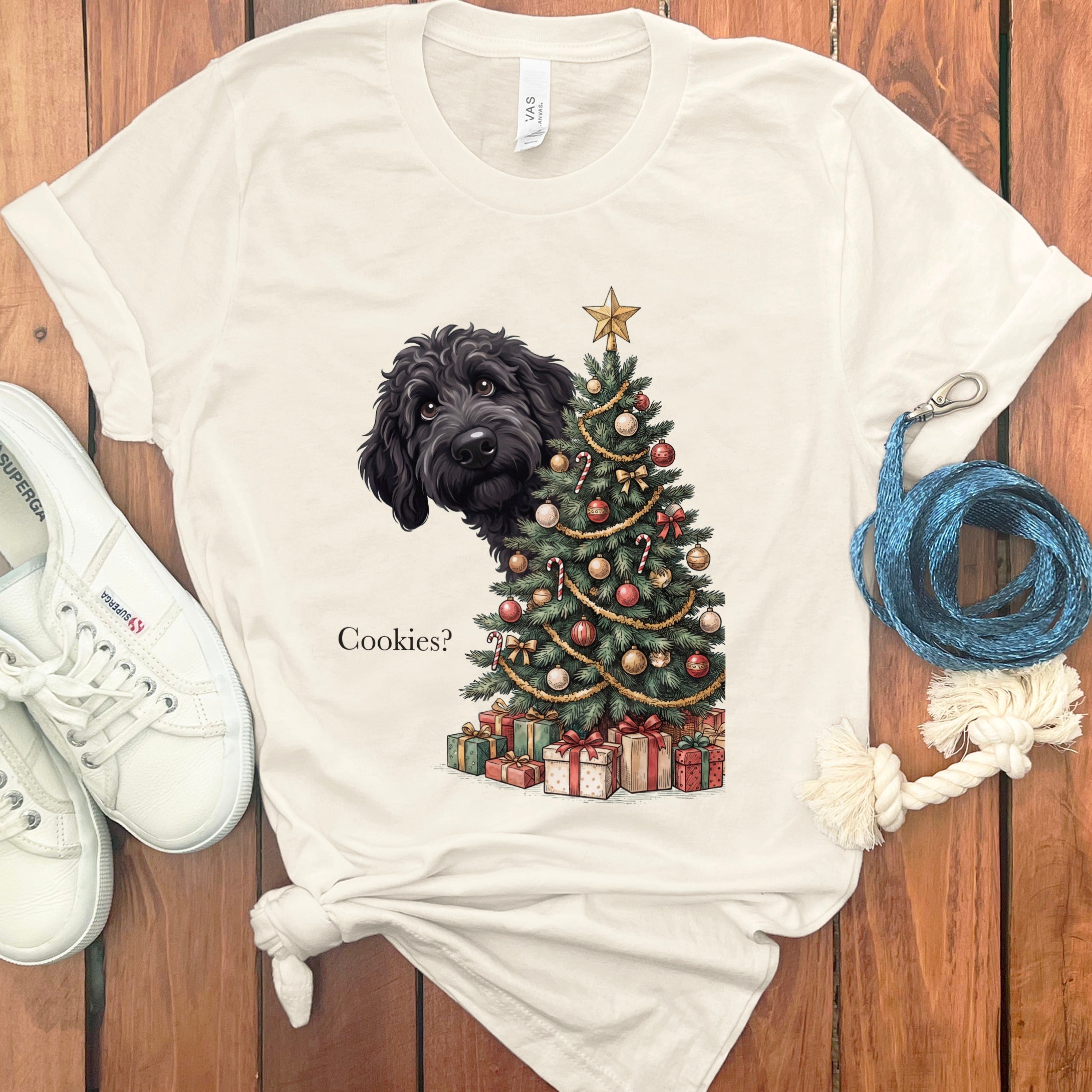 Black dog peeking from behind a decorated Christmas tree with presents below.