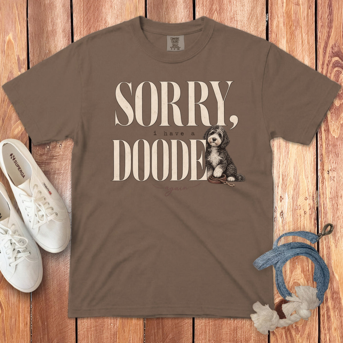 Brown t-shirt featuring the text SORRY, i have a DOODE again, and an illustration of a doodle dog.