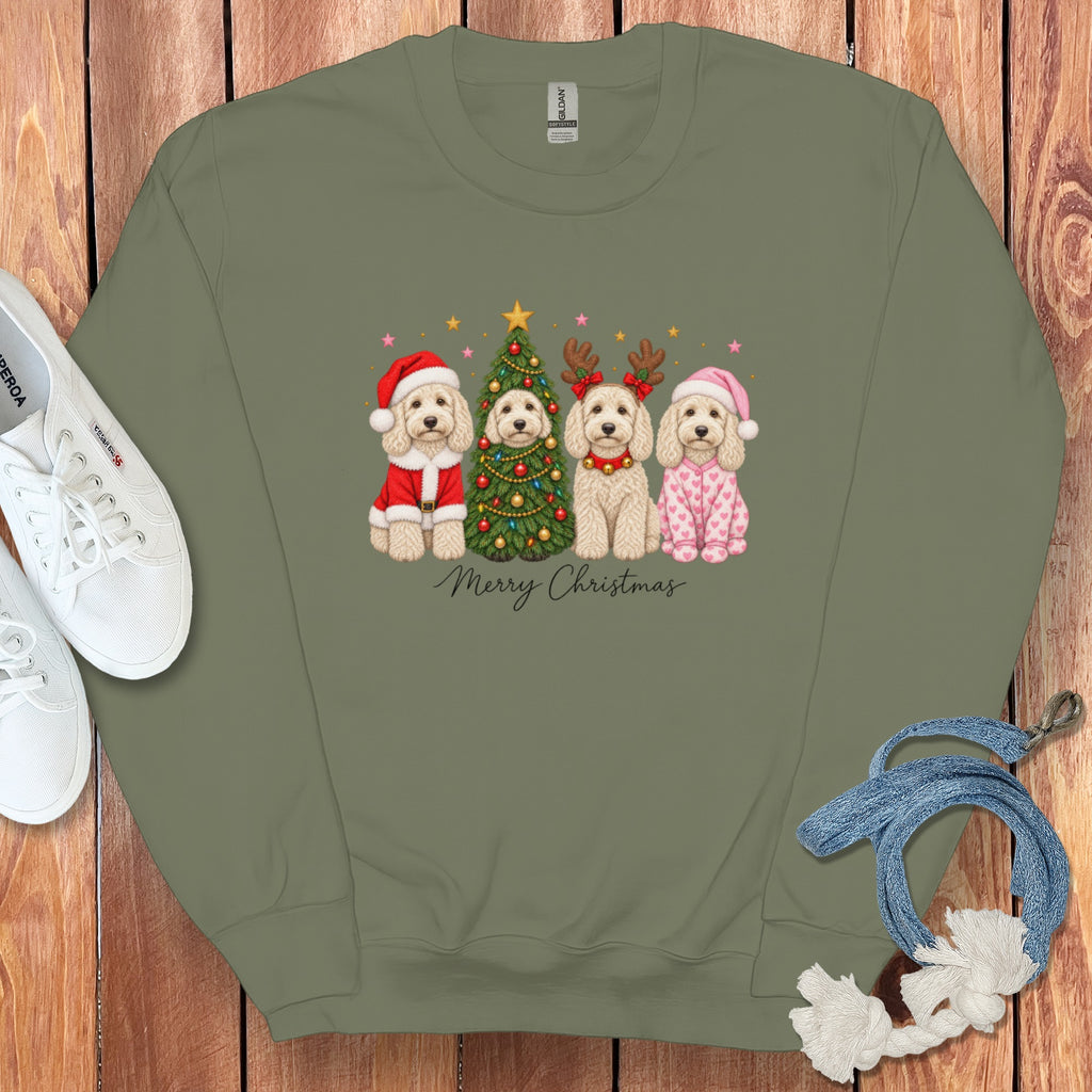 An olive green crewneck sweatshirt featuring a graphic of four doodle dogs in Christmas attire surrounding a decorated tree, with the text "Merry Christmas" below.
