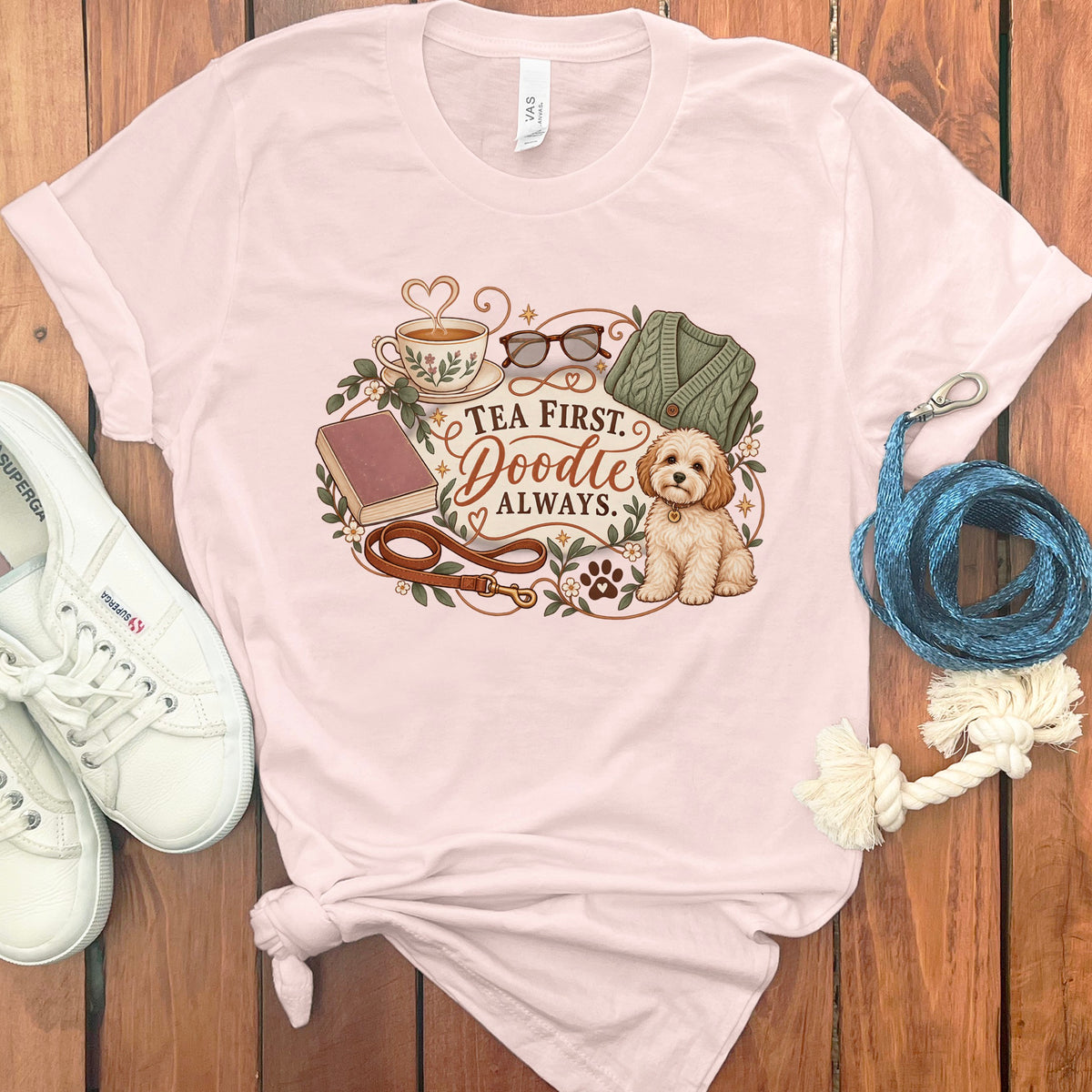 Light pink t-shirt with "Tea First. Doodle Always." text and doodle illustration.
