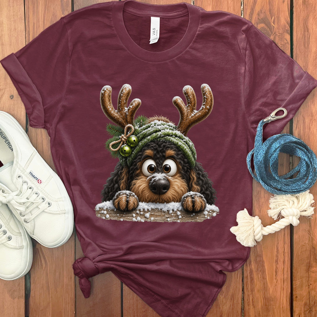 Maroon t-shirt with a cute dog wearing reindeer antlers and a green hat.