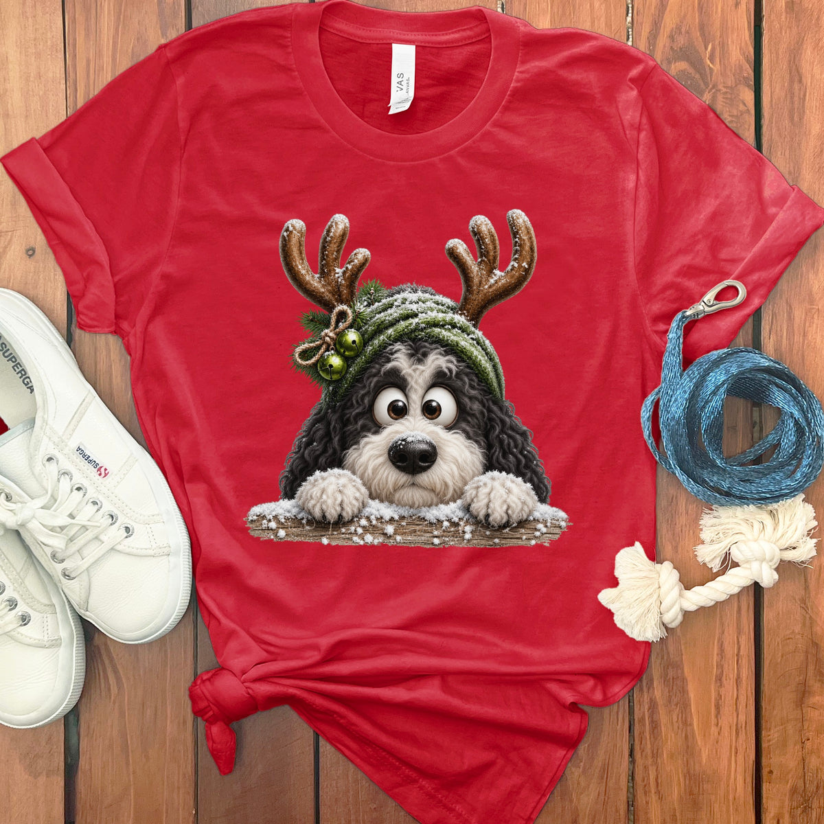 Red t-shirt with a cartoon bernedoodle dog wearing reindeer antlers and a hat.
