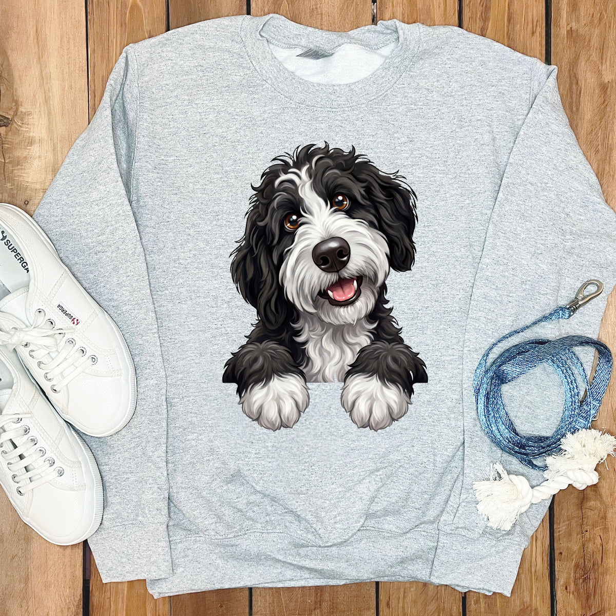 Light gray sweatshirt with a black and white dog illustration and white Superga sneakers.
