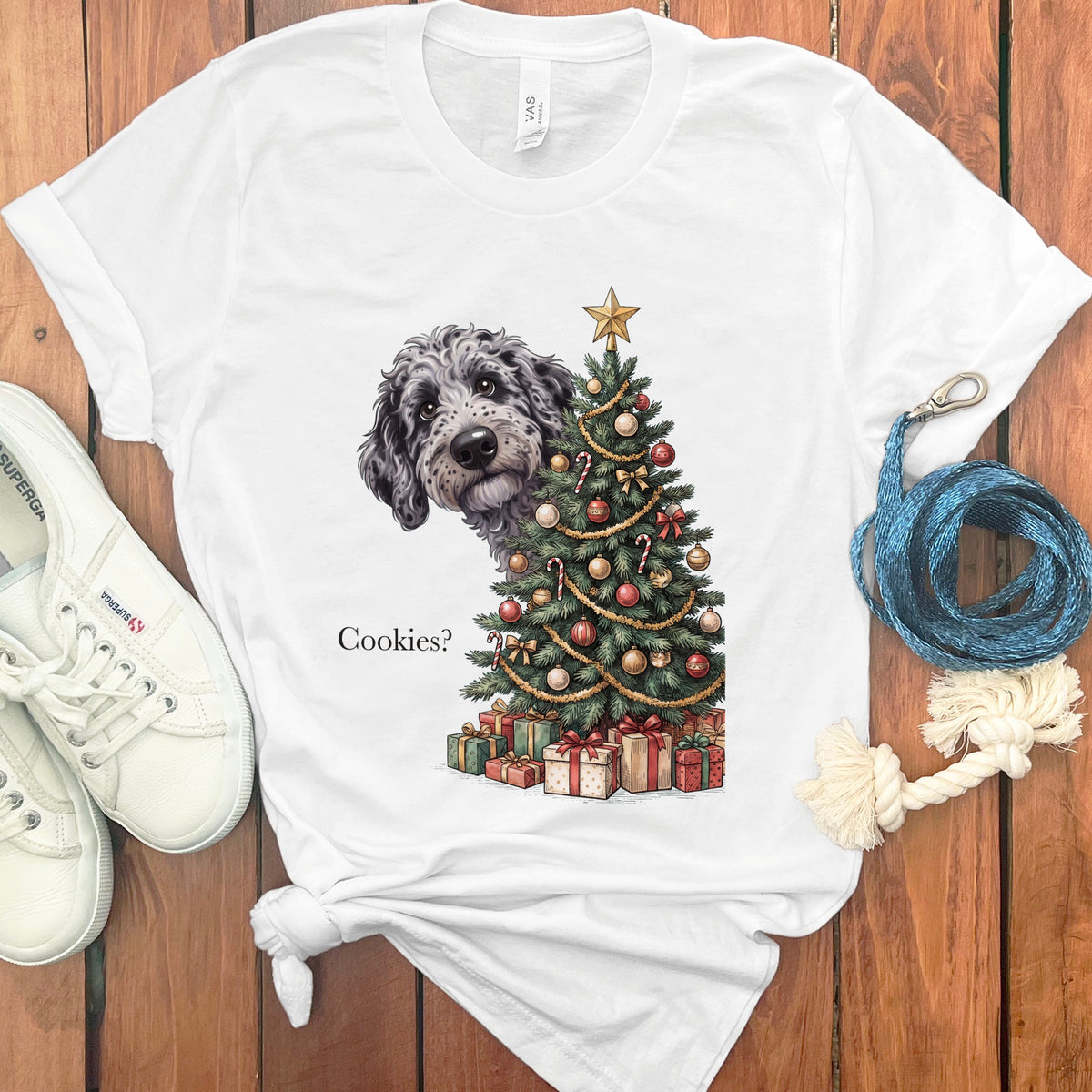 Dog peeking from behind Christmas tree with gifts and text "Cookies?".