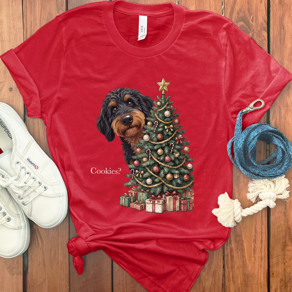 Red t-shirt with a dachshund peeking from behind a decorated Christmas tree and gifts.
