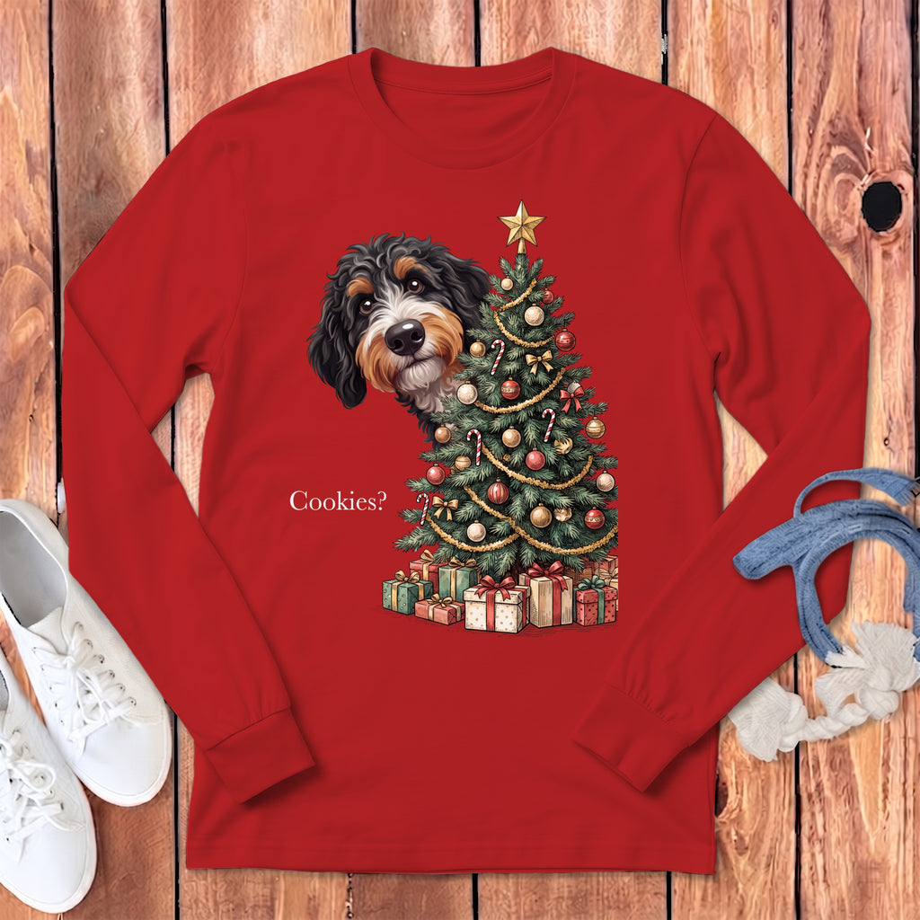 Bernese Mountain Dog peeking from behind a decorated Christmas tree and presents, text "Cookies?".
