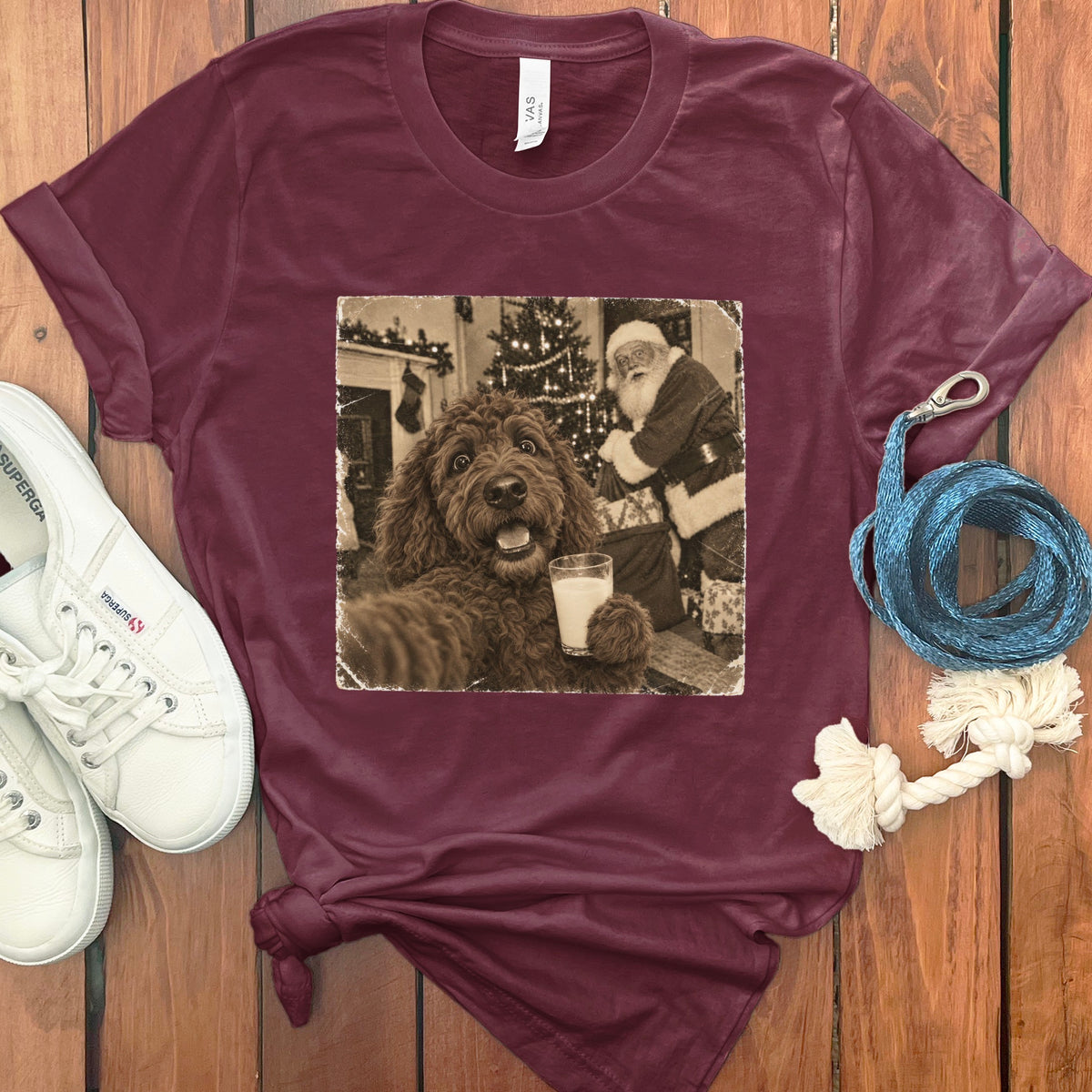 Maroon crewneck t-shirt featuring a vintage graphic of a fluffy dog holding a glass of milk with Santa Claus in the background.