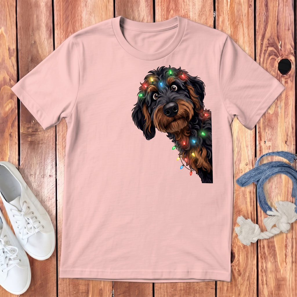 Pink t-shirt with a doodle dog wearing colorful Christmas lights.