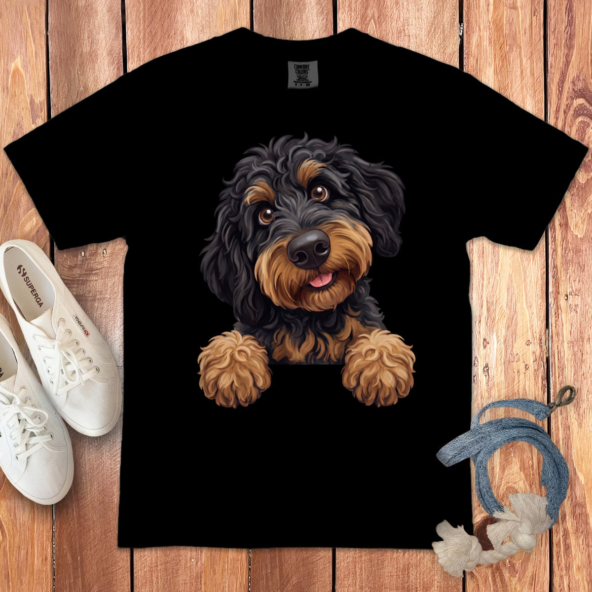 Black t-shirt with a drawing of a playful black and tan dog peeking over the edge.