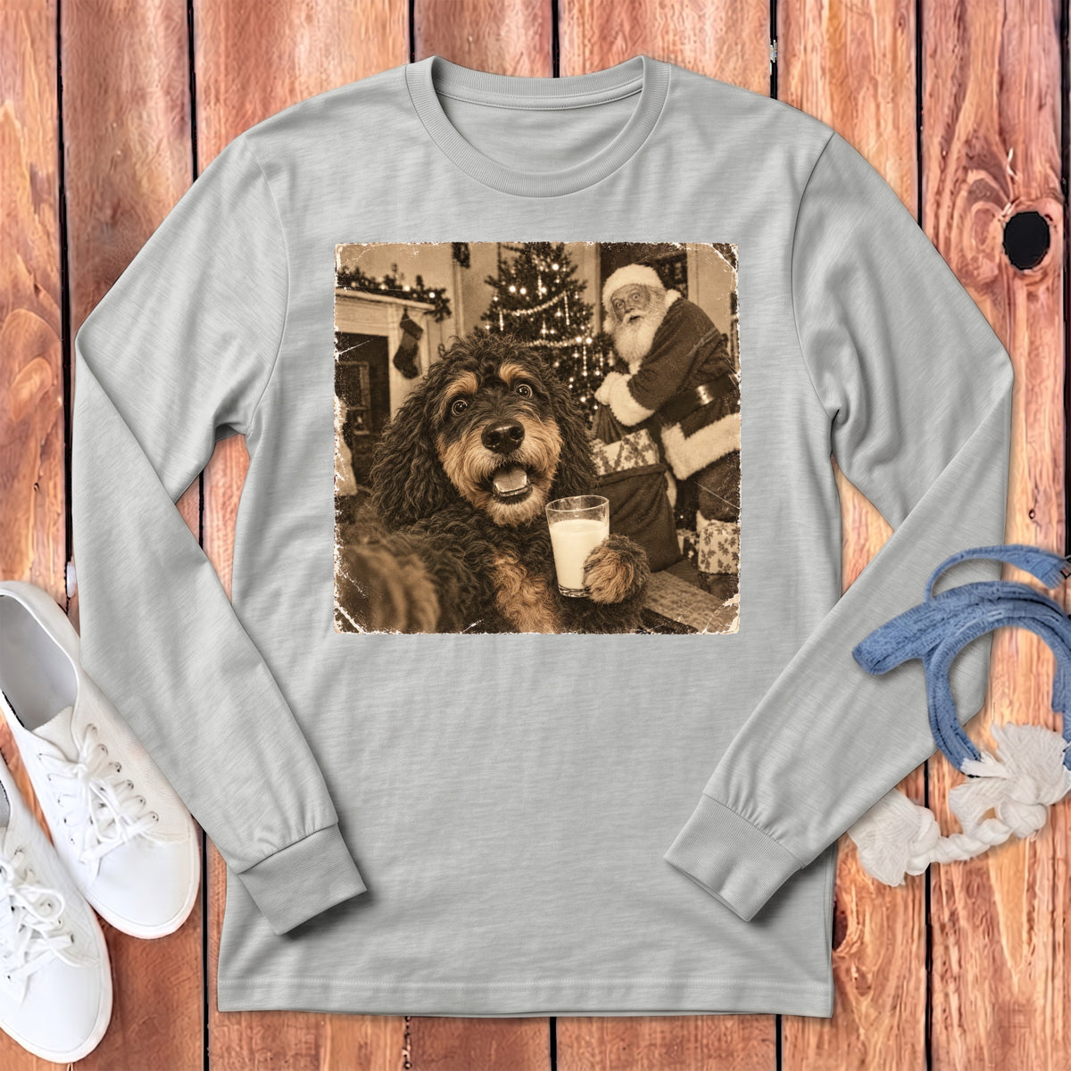 A light gray long-sleeve t-shirt features a graphic print of a dog holding a glass of milk with Santa Claus in the background.