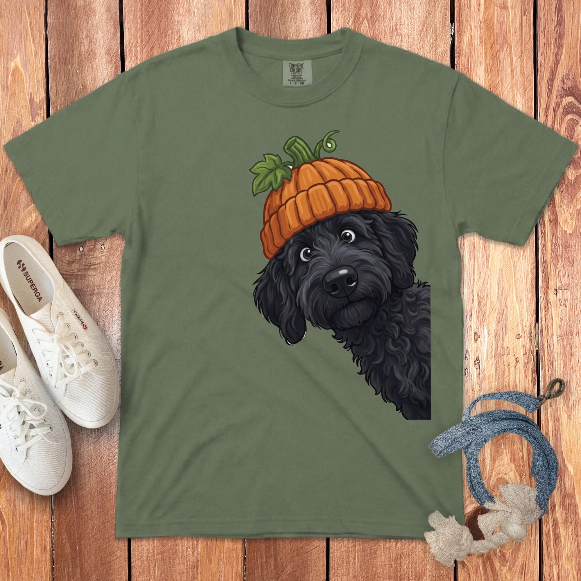 Green t-shirt with illustration of black dog wearing a pumpkin hat.