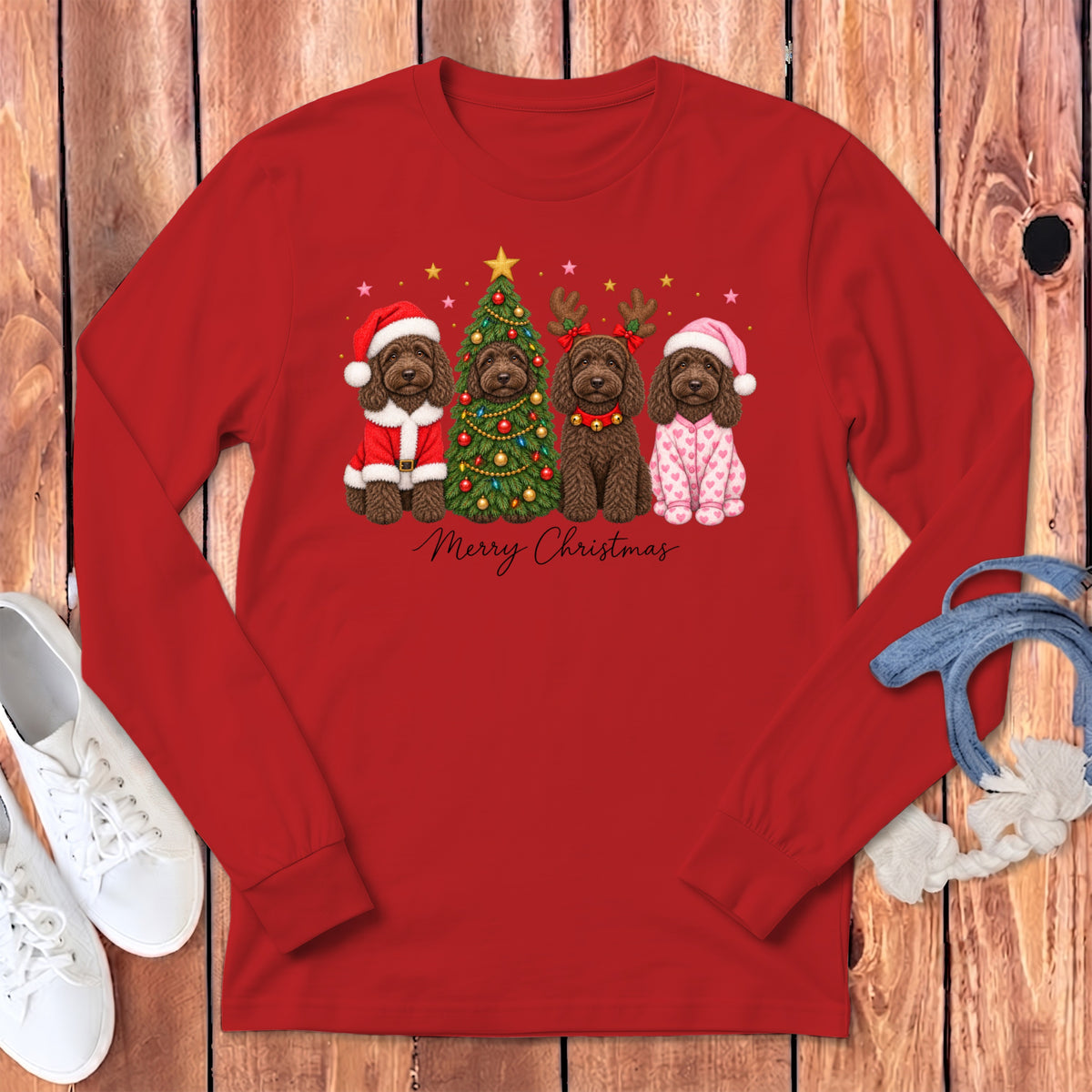 Red long-sleeved shirt featuring four labradoodles in holiday costumes next to a Christmas tree.