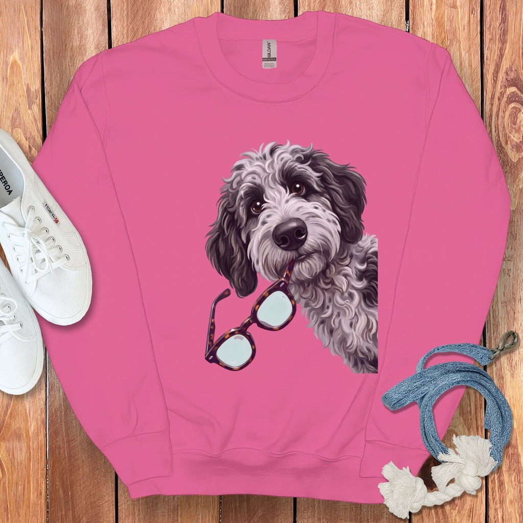 Pink crewneck sweatshirt featuring a graphic of a fluffy dog holding glasses in its mouth.