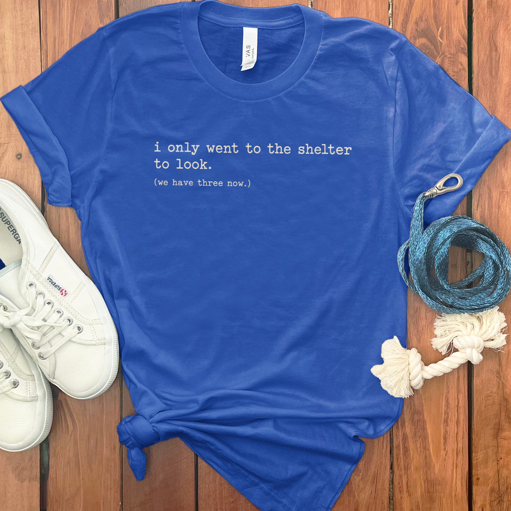 Blue t-shirt with white text: "i only went to the shelter to look. (we have three now.)"