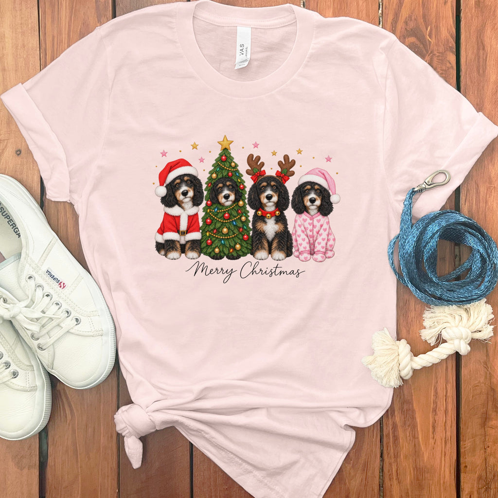 Light pink t-shirt featuring a graphic of four dogs dressed for Christmas, white sneakers, and blue rope.