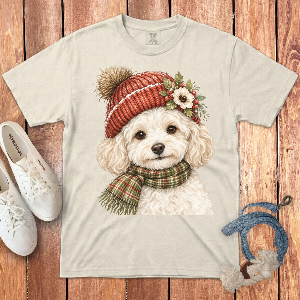 Cream t-shirt featuring a white poodle wearing a red knitted hat and plaid scarf.