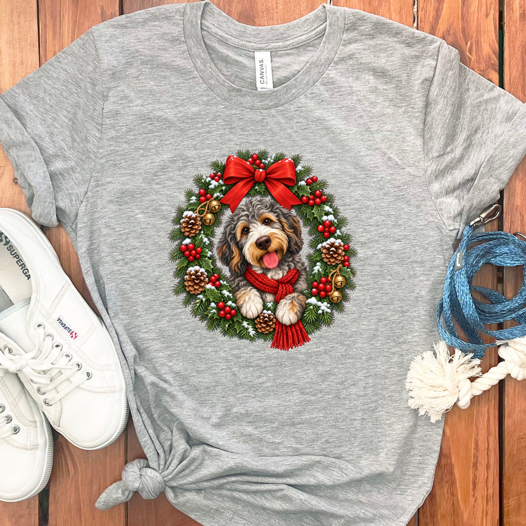 Heather gray t-shirt featuring a doodle dog wearing a red scarf inside a Christmas wreath.