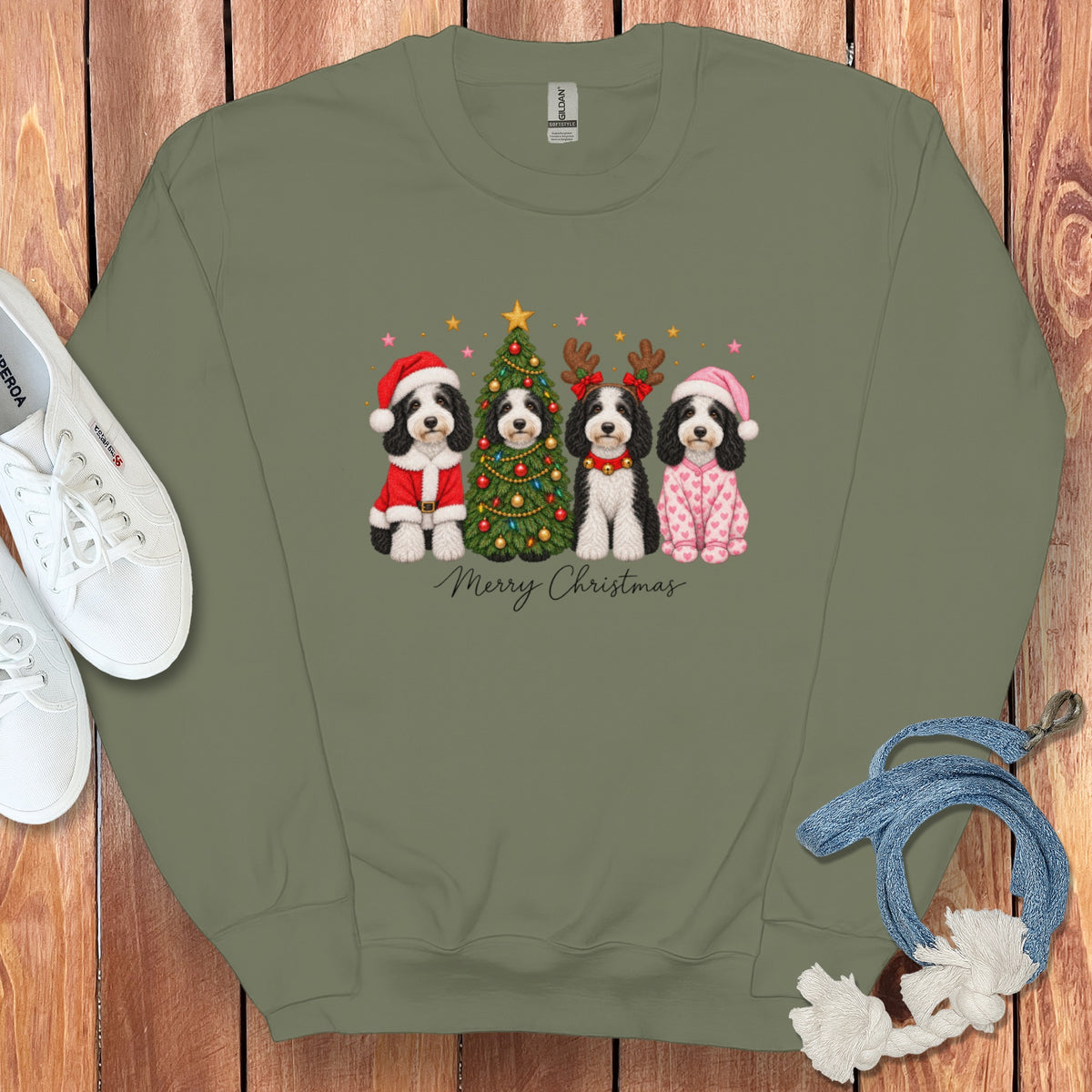 Olive green crewneck sweatshirt featuring a graphic of four dogs dressed for Christmas with the text Merry Christmas.
