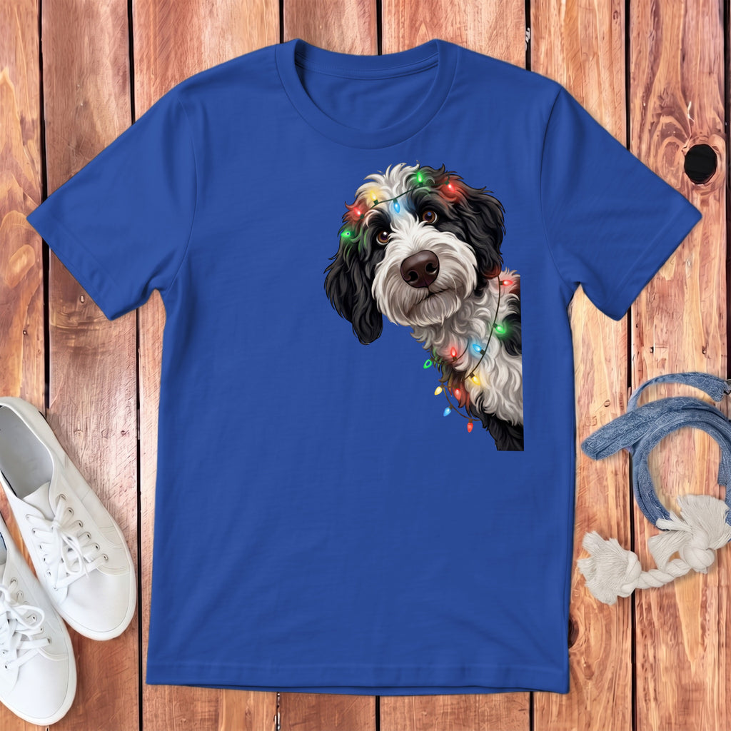 Blue t-shirt with a black and white dog wearing colorful Christmas lights.
