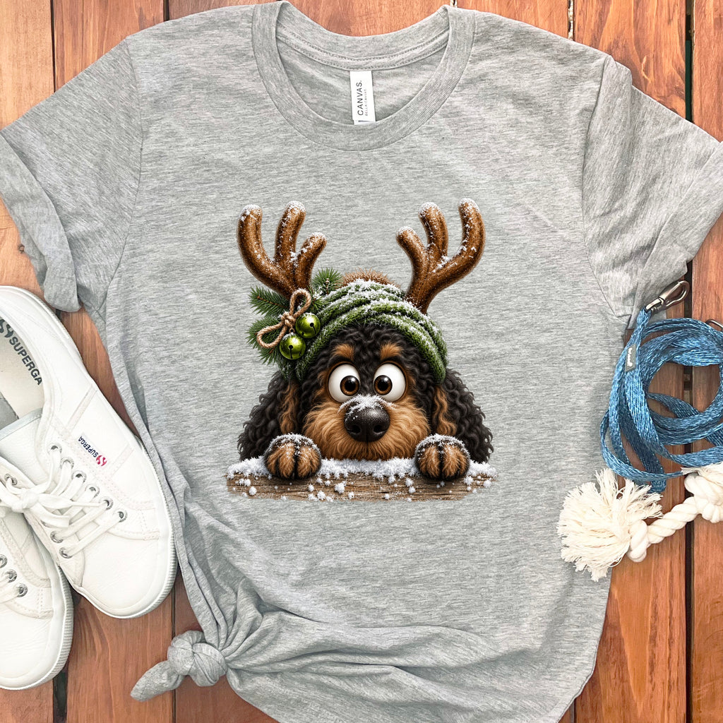 Grey t-shirt with a cartoon dog wearing antlers and a green hat, peeking over snow.