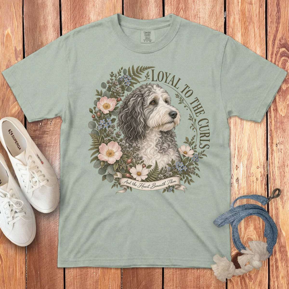 Light green t-shirt with a portrait of a dog surrounded by flowers and text.