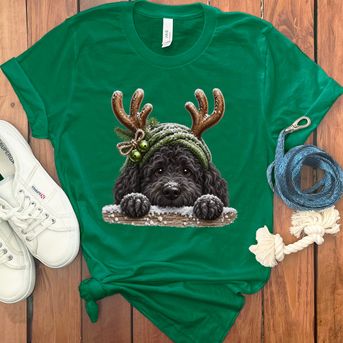 Green t-shirt with a black dog wearing reindeer antlers and a snowy hat.
