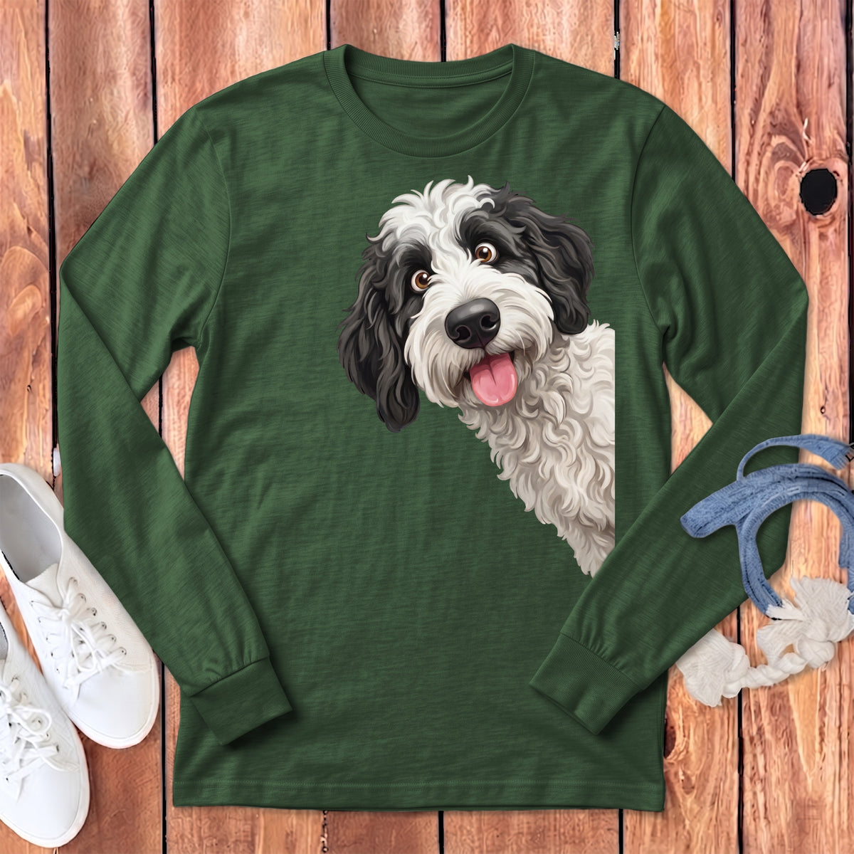 Green long sleeve shirt with a black and white dog illustration peaking from the side.