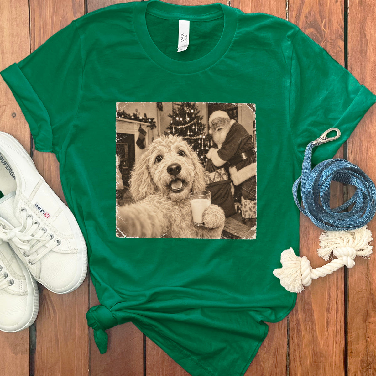 A green crewneck t-shirt featuring a vintage sepia graphic of a golden retriever holding a glass of milk with Santa Claus in the background.
