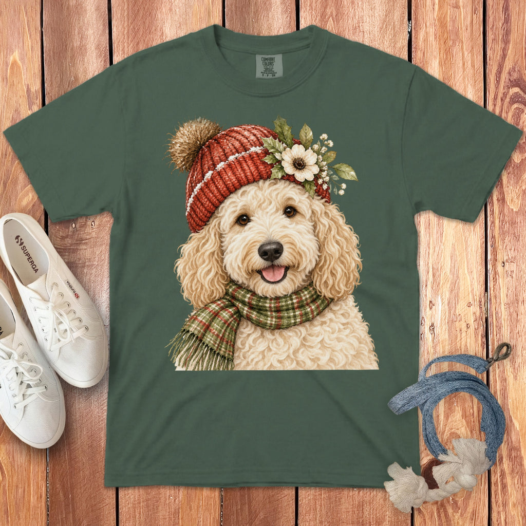 Green t-shirt with watercolor print of a fluffy goldendoodle wearing a red knit hat and scarf.