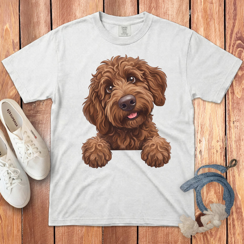White t-shirt with a brown doodle dog illustration peeking over a white surface.