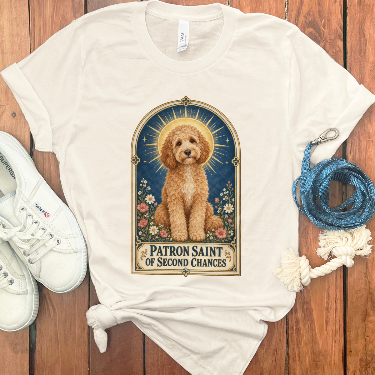 Cream t-shirt with artwork of a goldendoodle framed in an arch with flowers and text.