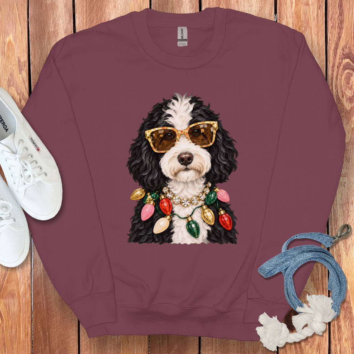 Bernedoodle wearing sunglasses and a Christmas light necklace.