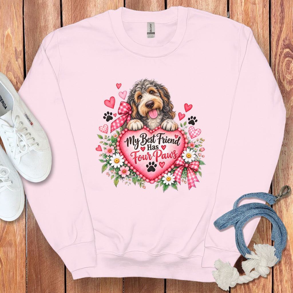 Light pink sweatshirt featuring a dog resting on a heart with the text "My Best Friend Has Four Paws".