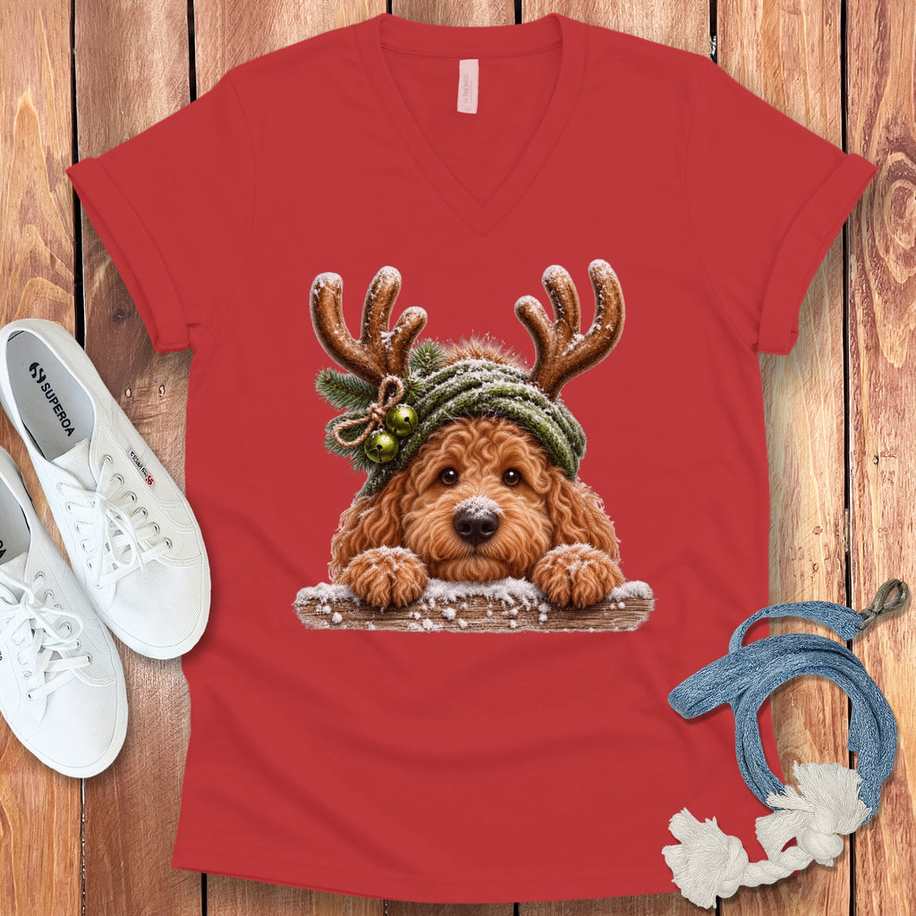 Red v-neck shirt with a golden retriever wearing reindeer antlers and a knitted hat.