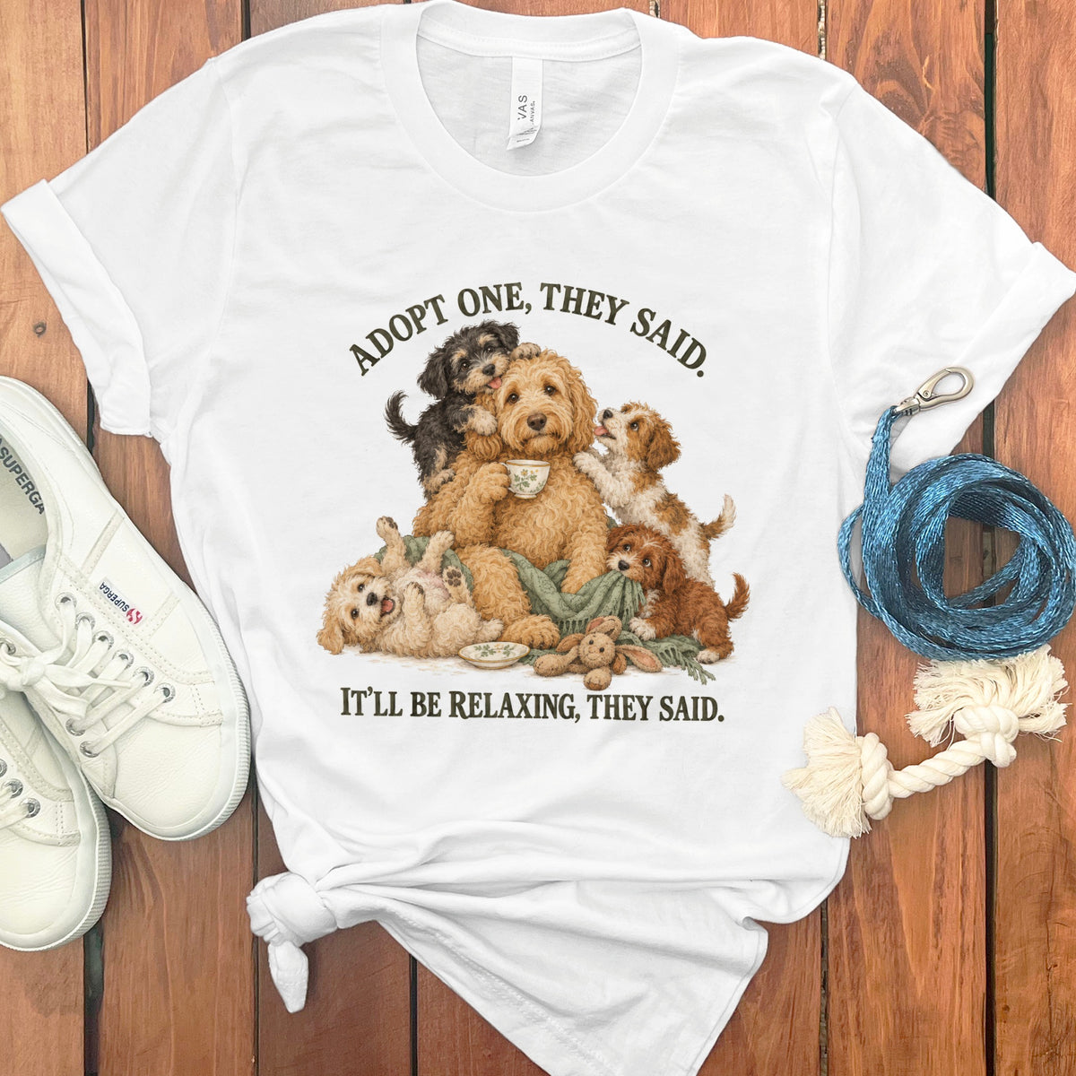 White t-shirt with dogs drinking tea and text "Adopt one, they said. It'll be relaxing, they said."