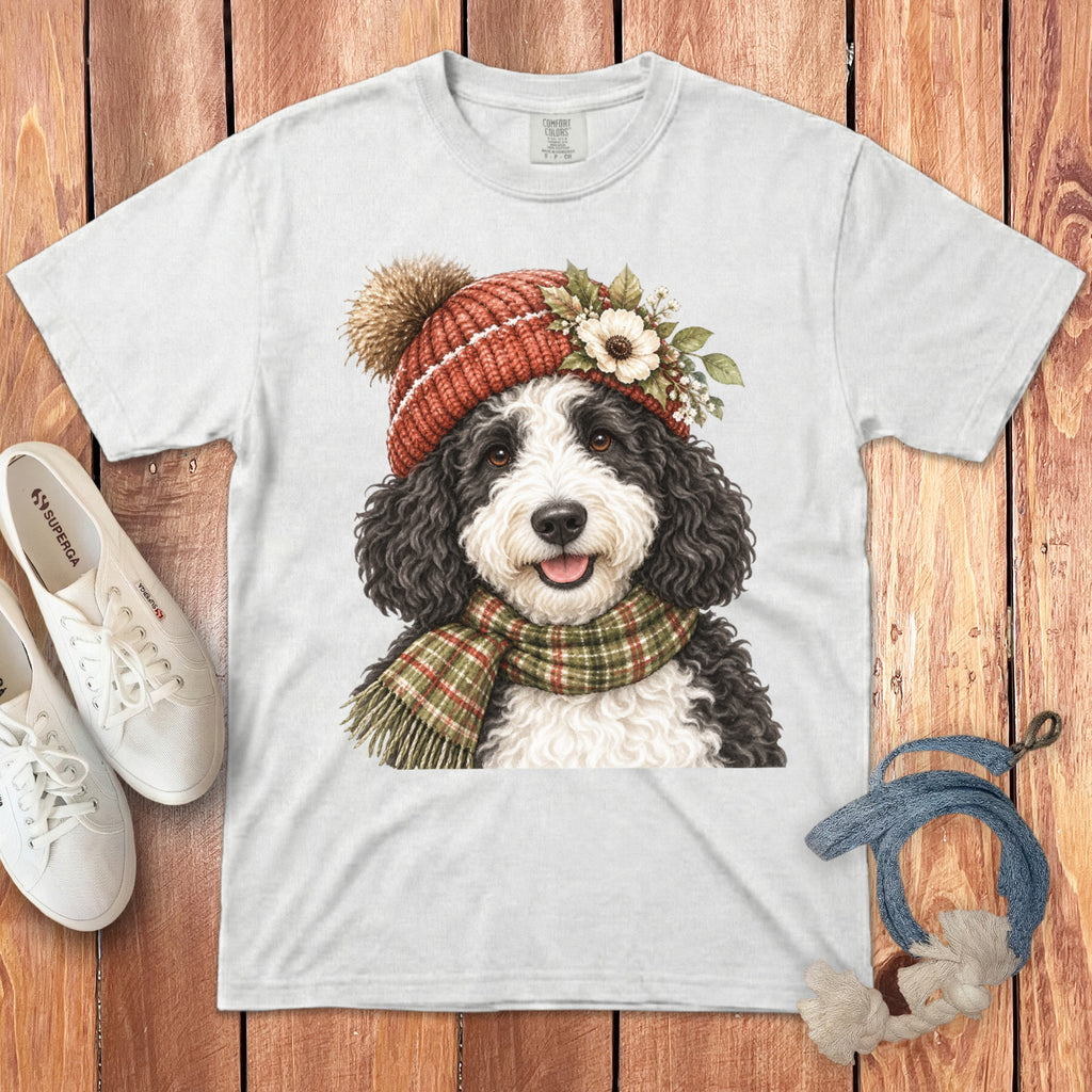 White t-shirt with a watercolor print of a Bernedoodle dog wearing a beanie and scarf.