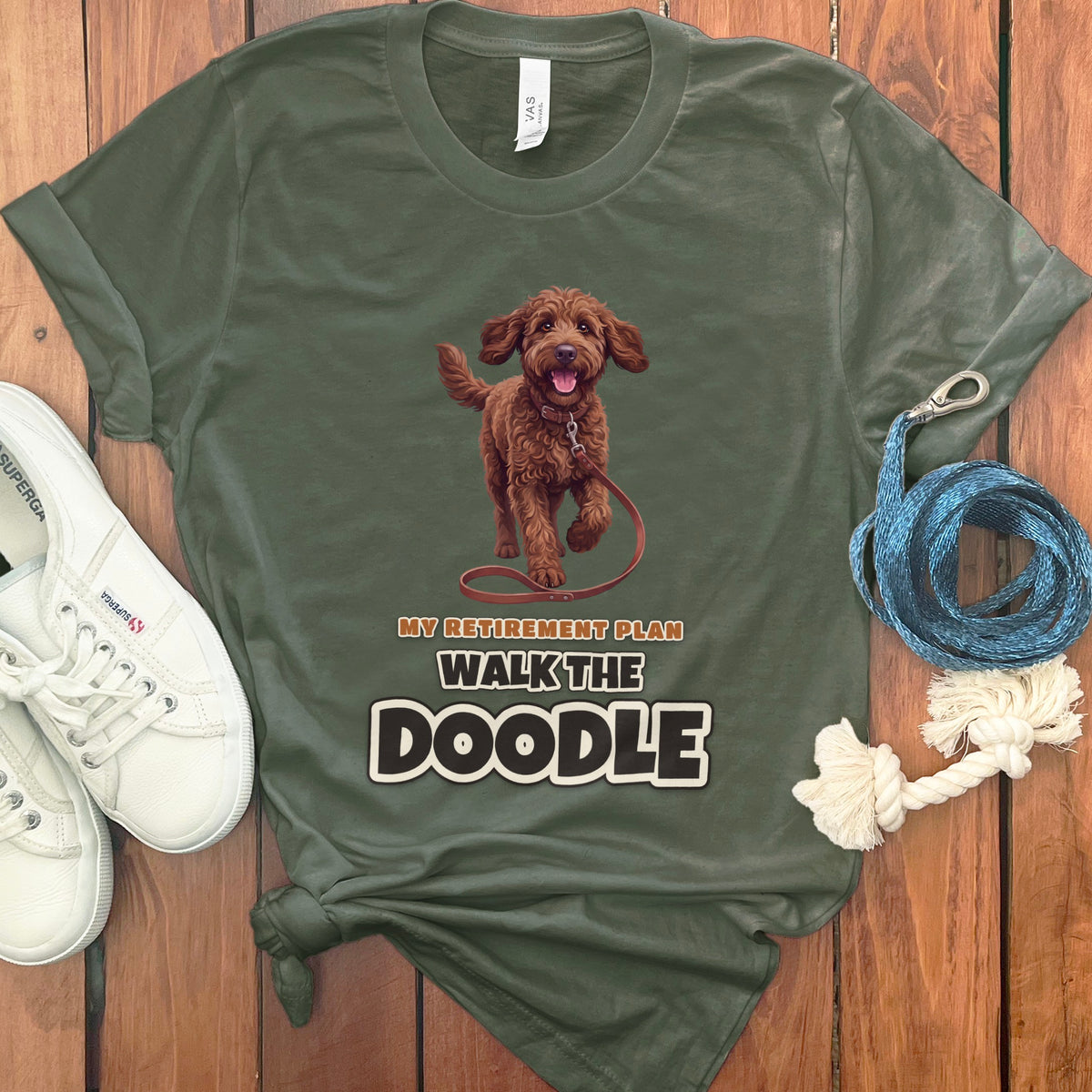 Olive t-shirt with a brown doodle and text "My Retirement Plan Walk the Doodle."