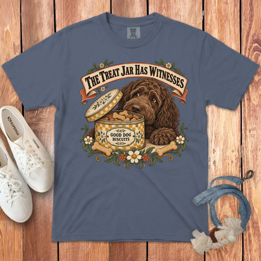 Blue t-shirt featuring a graphic of a brown dog with biscuits, surrounded by white sneakers and a leash.