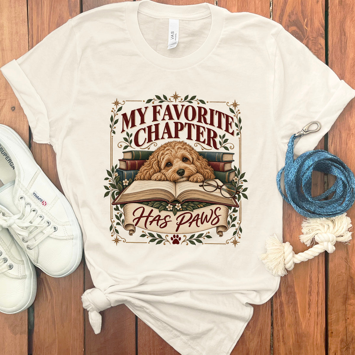 Cream t-shirt with dog on books reading, text "MY FAVORITE CHAPTER HAS PAWS".