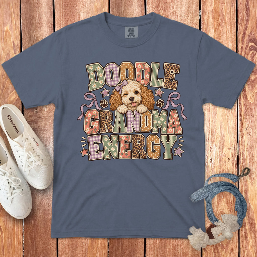 A slate blue t-shirt printed with Doodle Grandma Energy and a winking doodle puppy illustration.