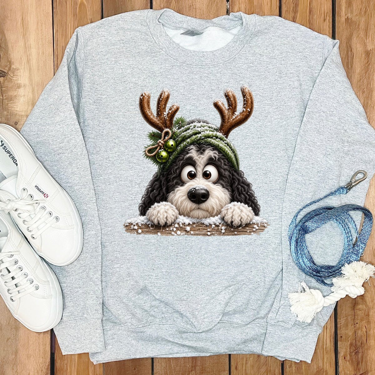Grey sweatshirt with a cartoon dog wearing reindeer antlers and a winter hat.