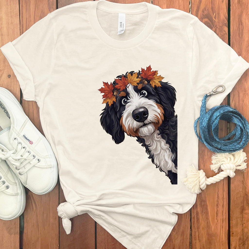 Bernese Mountain Dog wearing autumn leaves wreath glances curiously to the side.