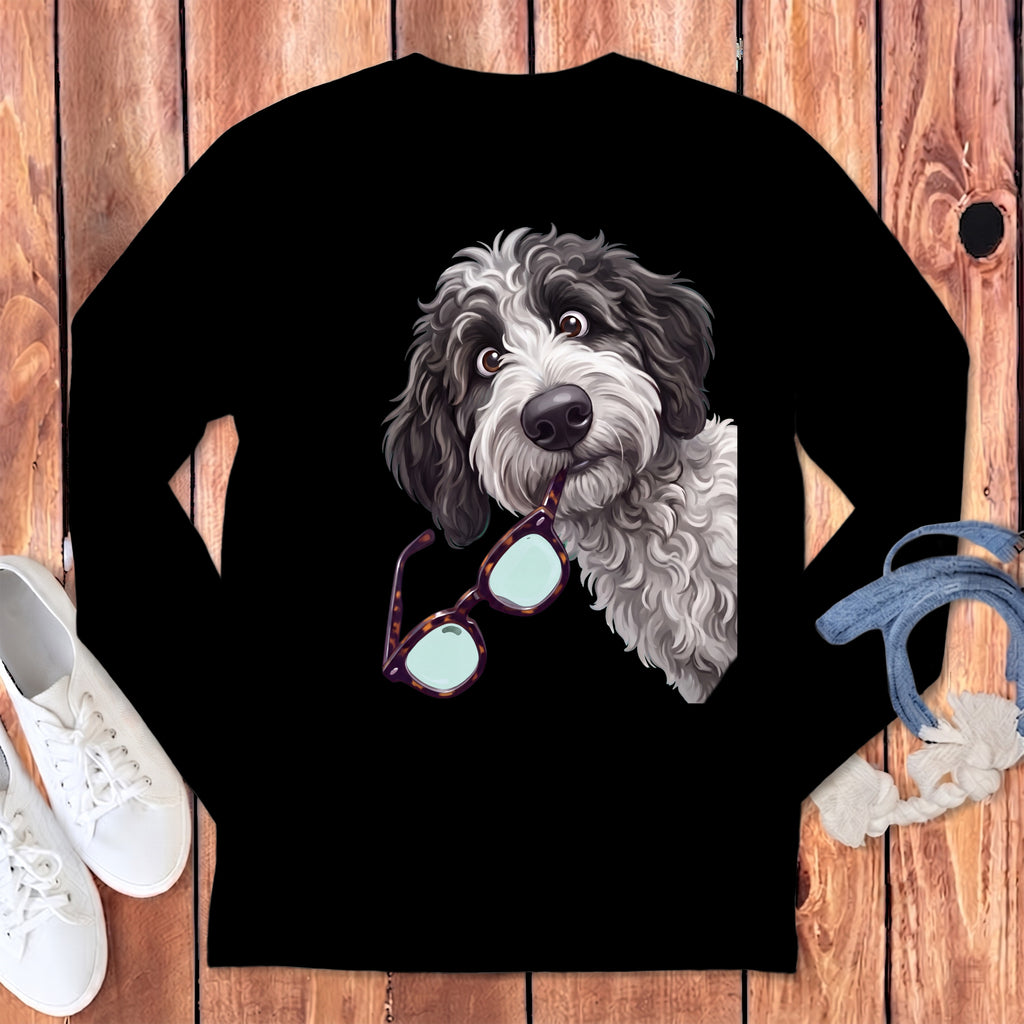 A black long-sleeved shirt features a graphic of a fluffy black and white dog holding glasses in its mouth.